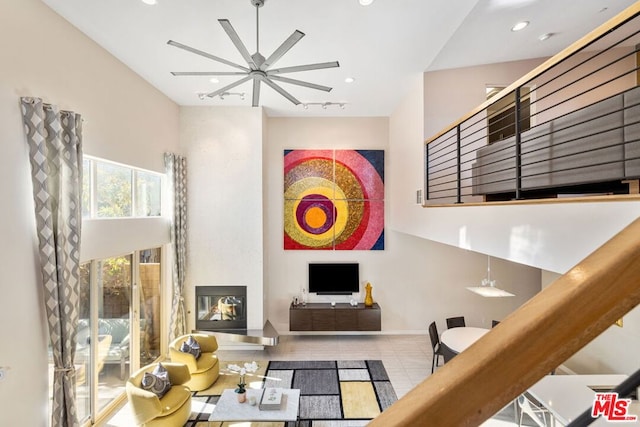 living room with tile patterned flooring, rail lighting, and ceiling fan