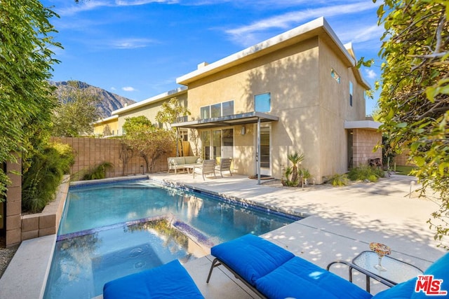 view of pool with an in ground hot tub, a mountain view, and a patio