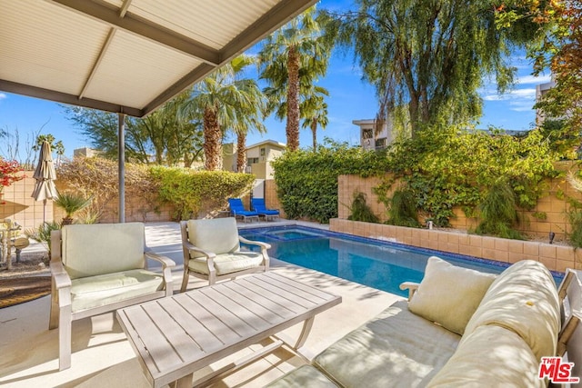 view of pool featuring an outdoor living space and a patio area