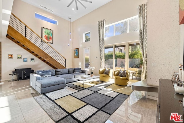 living room featuring light tile patterned flooring and a towering ceiling