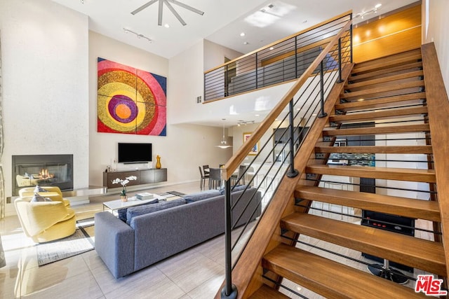 living room featuring track lighting, light tile patterned flooring, and a high ceiling