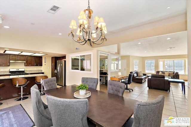 dining space with light tile patterned floors and an inviting chandelier