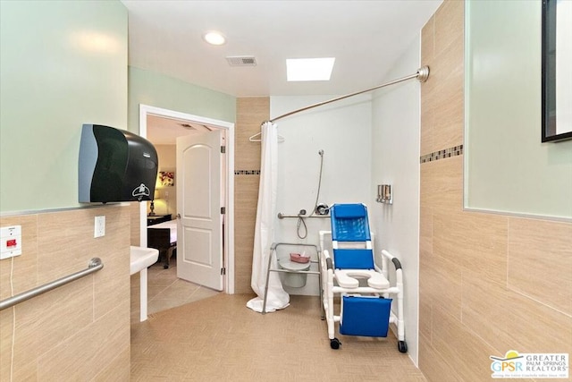 bathroom featuring tile walls, tile patterned floors, and walk in shower