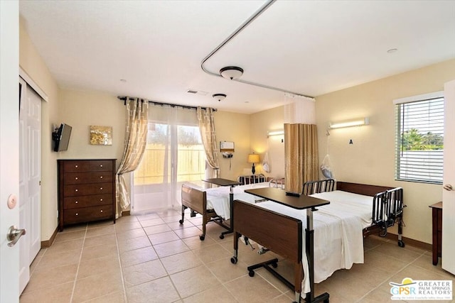 bedroom featuring light tile patterned floors, a closet, and a wall mounted air conditioner