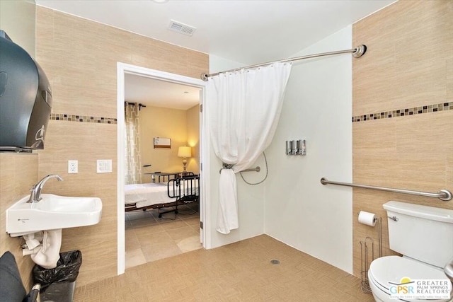 bathroom featuring toilet, tile patterned flooring, sink, and a shower with shower curtain