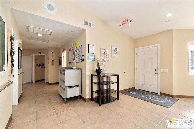 entrance foyer featuring lofted ceiling and light tile patterned flooring