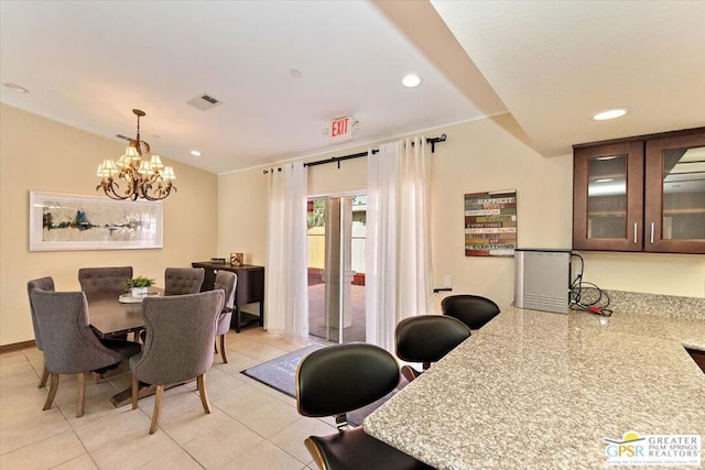 dining room with light tile patterned floors and an inviting chandelier