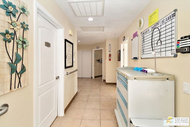 hall with light tile patterned floors