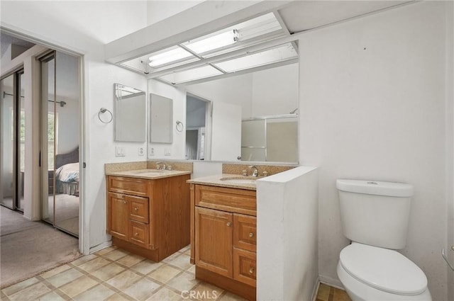 full bath featuring vanity, connected bathroom, a shower with shower door, and toilet