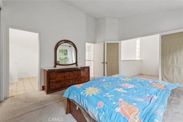 carpeted bedroom with high vaulted ceiling