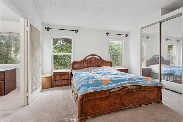 carpeted bedroom with a closet and a textured ceiling