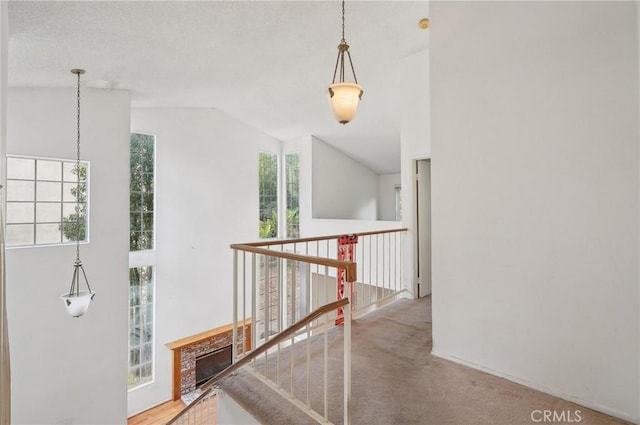 hall featuring vaulted ceiling and carpet