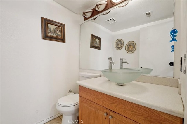 bathroom with tile patterned flooring, vanity, and toilet