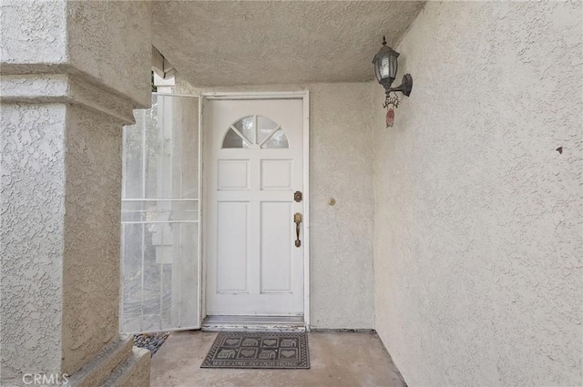doorway to property featuring stucco siding