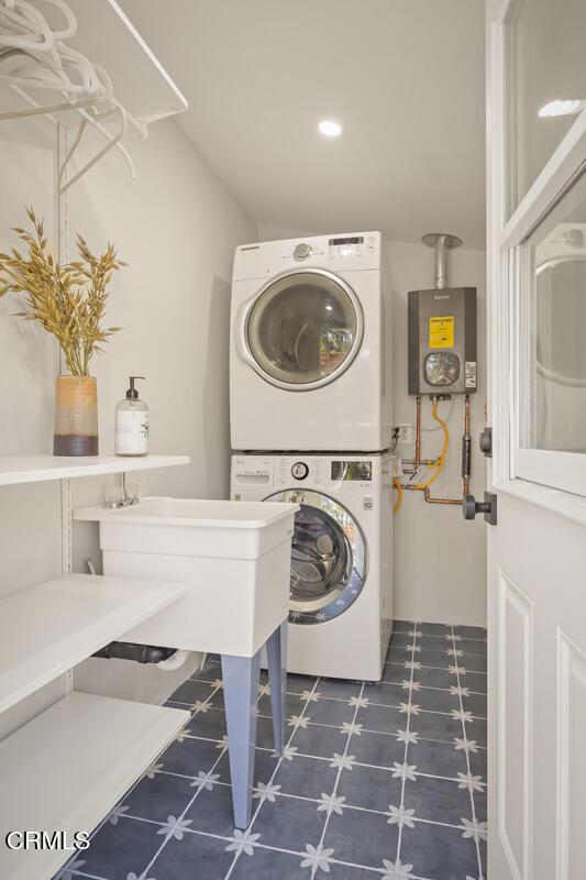 laundry room with stacked washer and dryer, laundry area, and recessed lighting