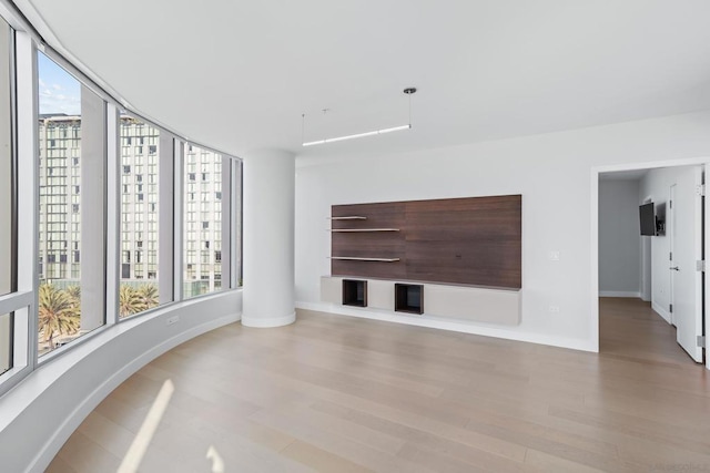 unfurnished living room with light hardwood / wood-style flooring and a wealth of natural light