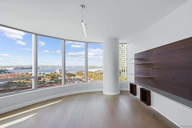 unfurnished living room with a water view and hardwood / wood-style floors