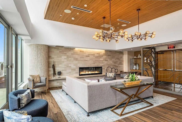 living room with plenty of natural light, a towering ceiling, a chandelier, and wood ceiling