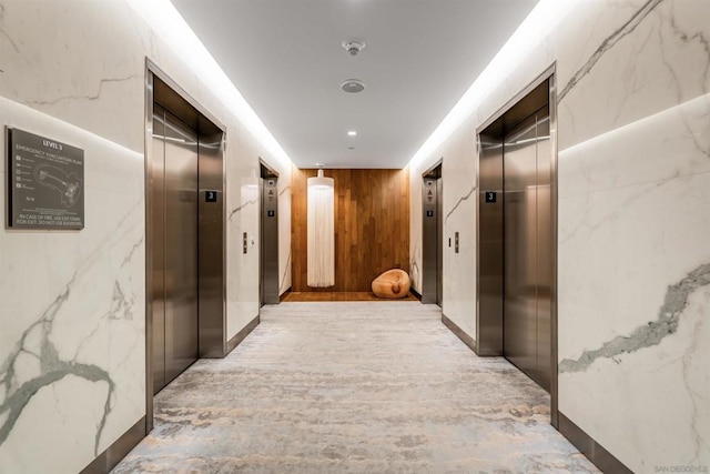 hall featuring elevator and wood walls