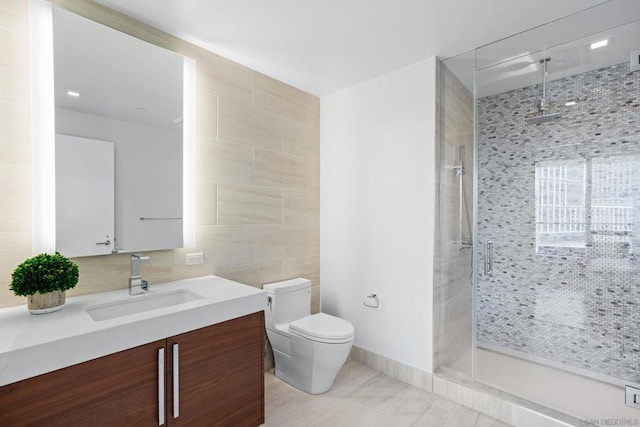 bathroom featuring tile walls, tile patterned flooring, vanity, tiled shower, and toilet