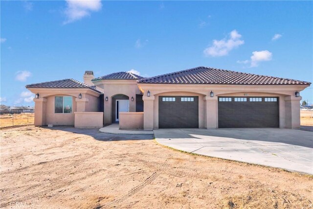 mediterranean / spanish home with a garage