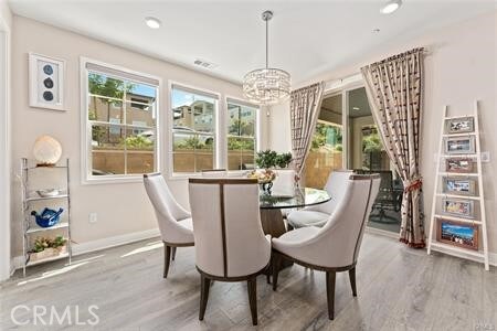 dining space featuring an inviting chandelier and light hardwood / wood-style flooring