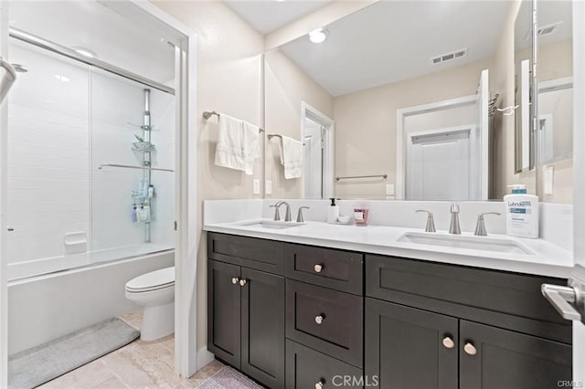 full bathroom featuring bath / shower combo with glass door, toilet, and vanity