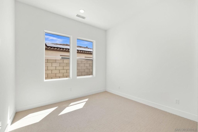 spare room featuring light colored carpet