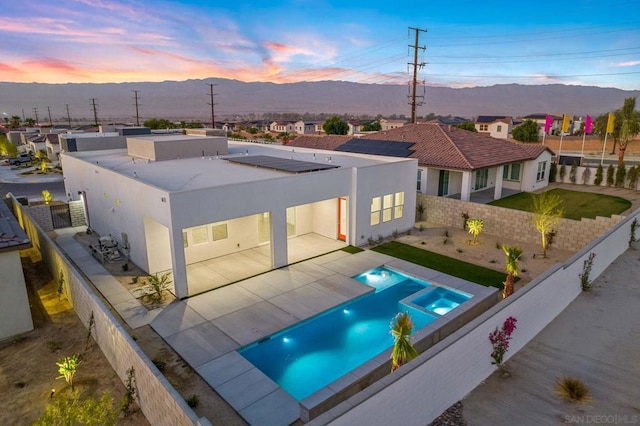 exterior space featuring a fenced in pool, a mountain view, and a patio