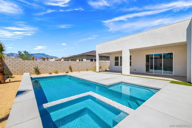 view of swimming pool with an in ground hot tub, a patio area, and a mountain view