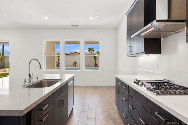 kitchen with sink, a wealth of natural light, wall chimney exhaust hood, and stainless steel appliances