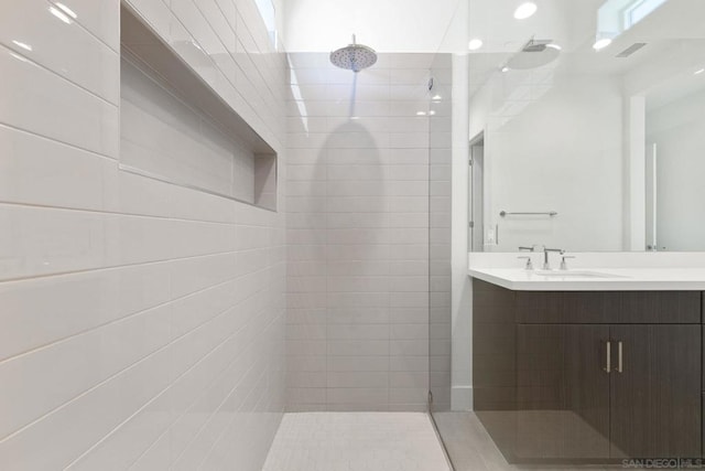 bathroom featuring vanity and tiled shower