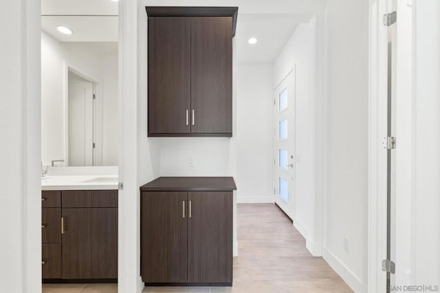 kitchen featuring light hardwood / wood-style floors and dark brown cabinetry