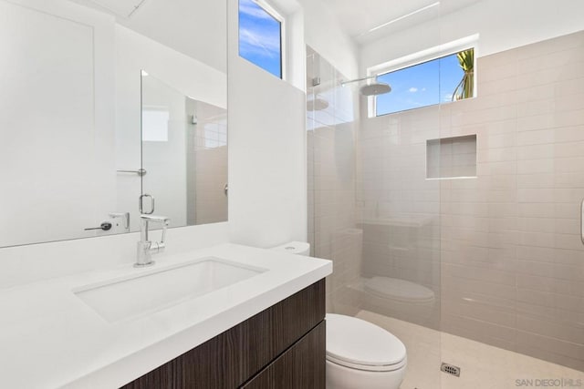 bathroom with toilet, a shower with shower door, and vanity