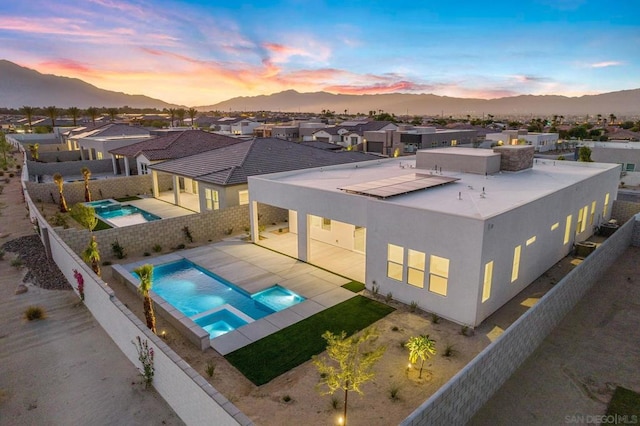 pool at dusk with a mountain view and a patio