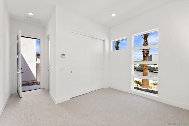 unfurnished bedroom featuring light carpet and a closet