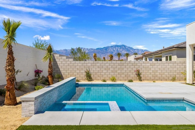 view of swimming pool with a mountain view and an in ground hot tub