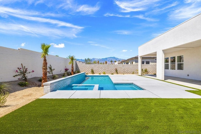 view of swimming pool featuring a patio area, a mountain view, and a yard