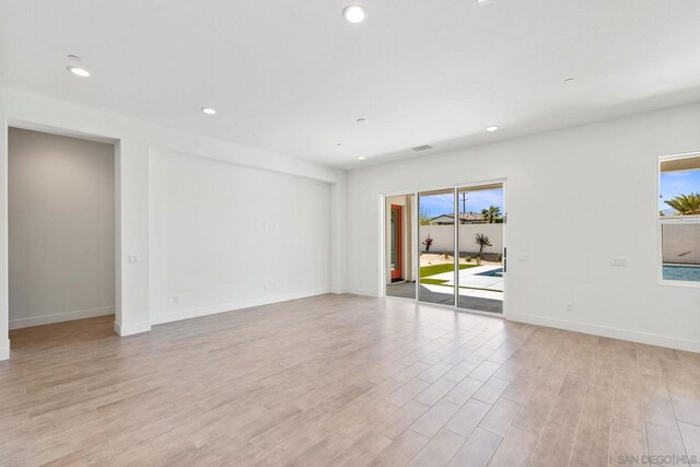 spare room with a healthy amount of sunlight and light hardwood / wood-style flooring