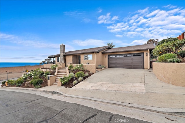 view of front of house with a garage and a water view