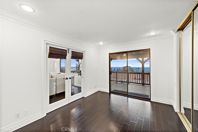 spare room with dark hardwood / wood-style flooring, crown molding, and french doors