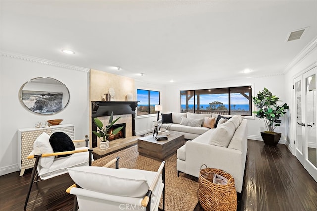 living room with a high end fireplace, ornamental molding, and dark hardwood / wood-style floors