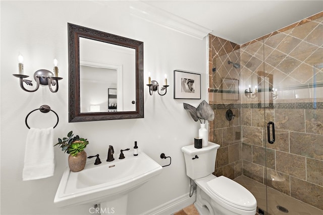 bathroom with toilet, ornamental molding, a shower with door, and sink