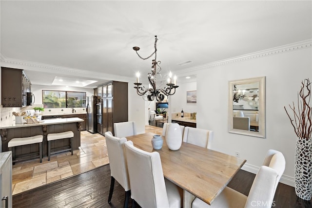 dining room with dark hardwood / wood-style flooring, crown molding, and a notable chandelier