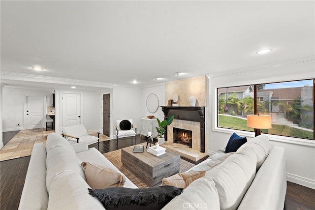 living room featuring a high end fireplace, ornamental molding, and hardwood / wood-style floors