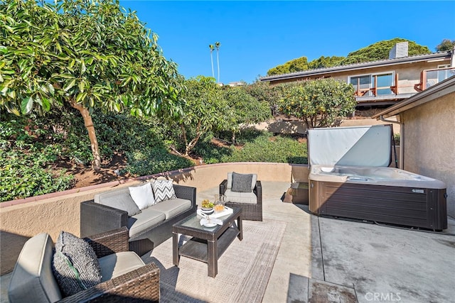 view of patio with an outdoor living space and a hot tub