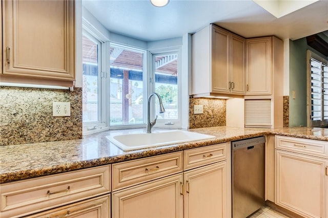 kitchen featuring backsplash, dishwasher, sink, and light stone counters