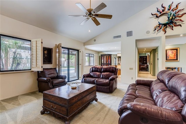 carpeted living room with ceiling fan and high vaulted ceiling