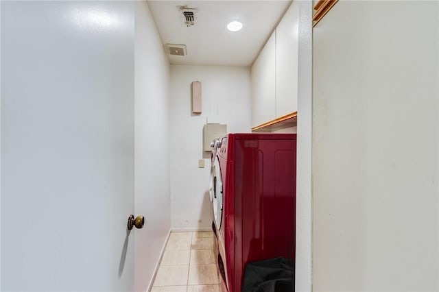 corridor with separate washer and dryer and light tile patterned floors