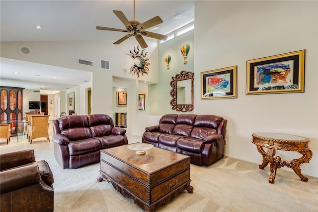 carpeted living room with high vaulted ceiling and ceiling fan